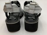a close up of a pair of black and silver shoes on a white surface
