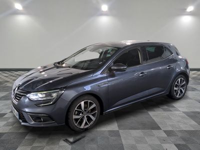 a grey car is parked on a checkered floor in a garage