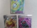 three different pokemon cards are sitting on a white surface