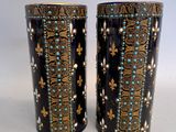 pair of black and gold vases with blue and white designs