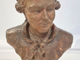 buste en bronze d'un homme portant un nœud papillon, posé sur une table