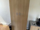a wooden cabinet in the corner of a room