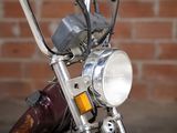 a close up of a motorcycle headlight with a brick wall in the background