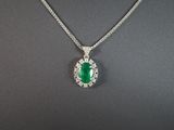 un pendentif en émeraude et diamant sur une chaîne en argent
