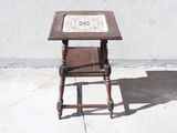 une petite table en bois recouverte d'un plateau en faïence