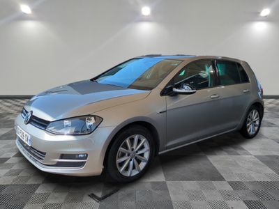 Une Volkswagen Golf argentée est garée dans une pièce dont le sol est en damier.