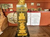 a gold and black clock sitting on a wooden table