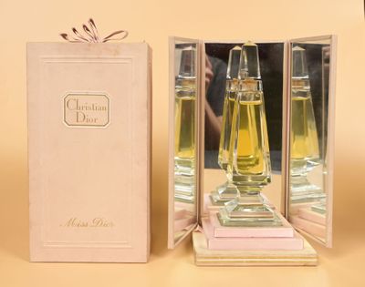 a bottle of perfume sitting in a box next to a box of perfumes