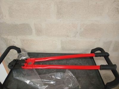 deux coupe-tubes rouges posés sur un chariot noir