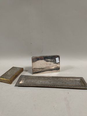 deux pièces métalliques argentées sont posées sur une surface blanche