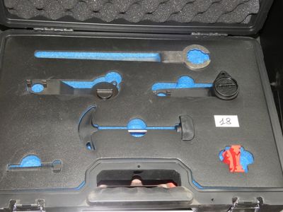 une mallette noire contenant des outils, posée sur une table