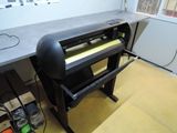 une grande imprimante posée sur un bureau dans une pièce