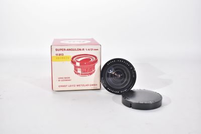 an old camera lens sitting on top of a box next to it ' s box