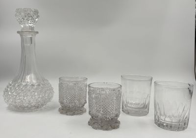 cinq verres et une carafe posés sur une table