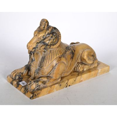 statue d'un lion posée sur un socle en pierre, sur fond blanc