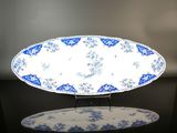 une assiette bleue et blanche posée sur une table noire