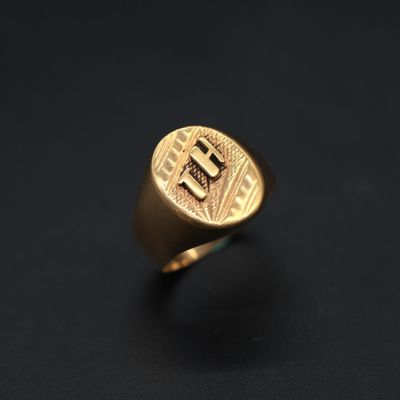 a gold signet ring with the letter e on it