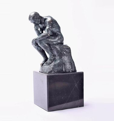 a statue of a man that is sitting on top of a box