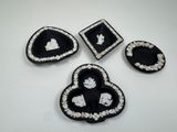 four pieces of black and white brooches on a white surface