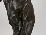 bronze statue of a dog holding a tennis racket on a white background