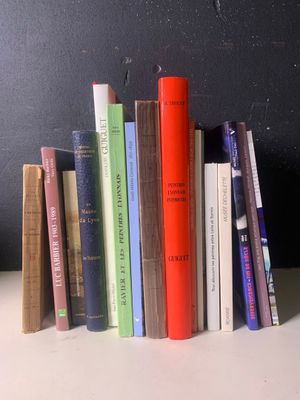 une pile de livres posée sur une table près d'un mur noir