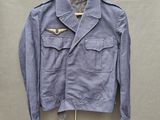 une veste bleue suspendue à un cintre accroché au mur