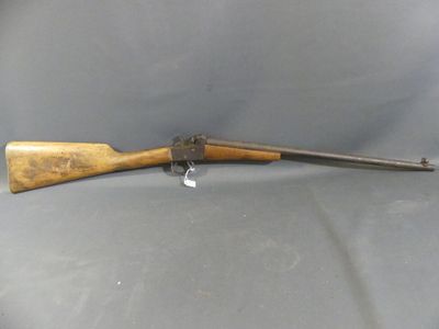an old rifle with a wooden handle on a gray surface
