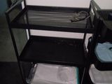 a black shelf with a computer on top of it