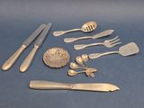 a lot of silverware on a blue surface