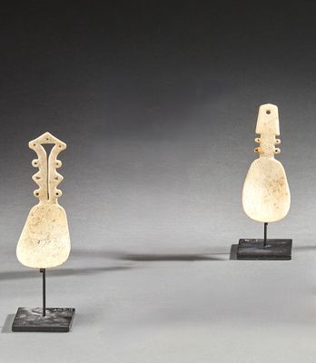 trois œuvres d'art sont exposées sur des socles posés sur une surface grise