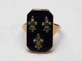 une image représentant une bague dorée et noire ornée de fleurons