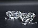 pair of clear glass candlestick holders on a black surface