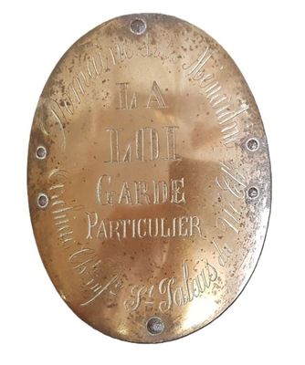 une plaque en laiton portant une inscription sur fond blanc