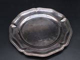 an antique silver plate on a black background