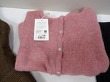 a pink sweater and a brown jacket on a shelf