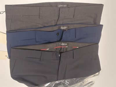 three men ' s pants are lined up on a plastic bag