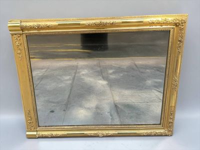 a gold framed mirror sitting on top of a white table
