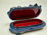 a small blue box with a red lid on a table