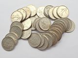 pile of silver coins on a white surface