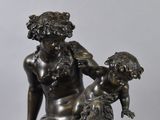 an antique bronze statue of a woman holding a child