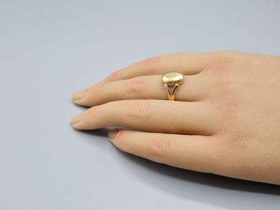 Quelqu'un porte une bague en or avec un cœur au milieu.