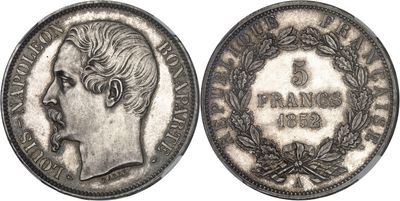 a silver coin with a woman ' s head and laurels on it