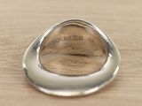 a close up of a silver ring on a wooden surface