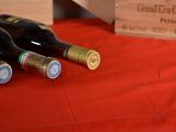 several bottles of wine are lined up on a red table