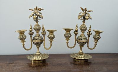 pair of antique brass candelabs on a wooden table