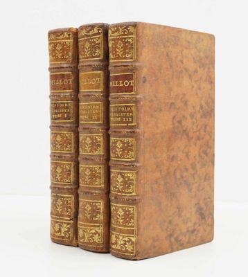 trois livres superposés sur une surface blanche
