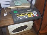 un ordinateur posé sur une étagère à côté d'un micro-ondes