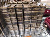 Plusieurs vieux livres sont empilés sur une table en verre dans un magasin
