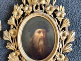 deux photos encadrées représentant un homme barbu et coiffé d'un chapeau, posant sur un tapis bleu