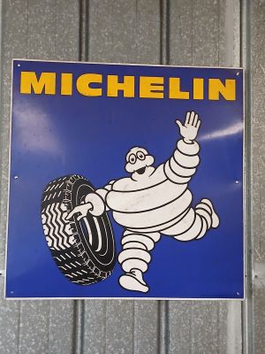 a blue sign with a picture of a cartoon character holding a tire
